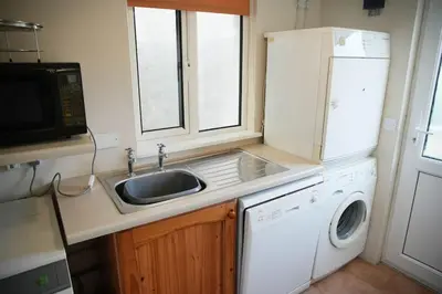 a kitchen with a sink and a washing machine at Haven Cottage, Port Isaac Bay Holidays in Port Isaac