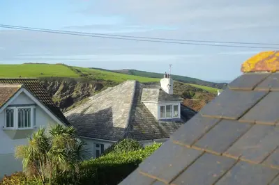 a view of roofs of houses and a church at Haven Cottage, Port Isaac Bay Holidays in Port Isaac