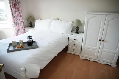a white bed with a tray of food on it at Haven Cottage, Port Isaac Bay Holidays in Port Isaac