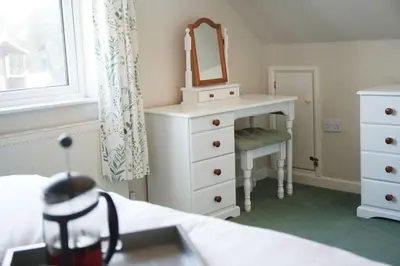 a bedroom with a dresser with a mirror on it at Haven Cottage, Port Isaac Bay Holidays in Port Isaac