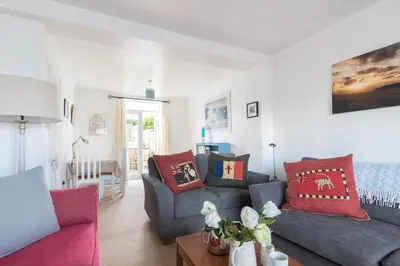a living room with a blue couch and red pillows at Tregenna, Port Isaac Bay Holiday in Port Isaac