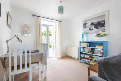 a living room with a desk and a book shelf at Tregenna, Port Isaac Bay Holiday in Port Isaac