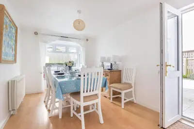 a dining room with a blue table and chairs at Tregenna, Port Isaac Bay Holiday in Port Isaac