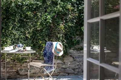 a table and a chair with a tea set on it at Gulls Roost, Port Isaac Bay Holidays in Port Isaac