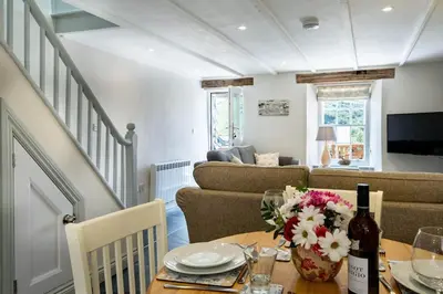 a living room with a table and a couch at Gulls Roost, Port Isaac Bay Holidays in Port Isaac