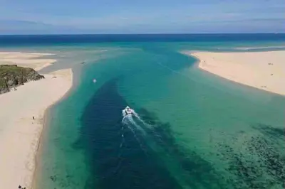 a boat in the water on a beach at Family friendly home by the beach in Hayle