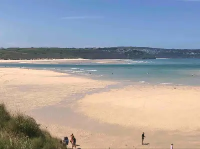 two people standing on a beach with the ocean at Family friendly home by the beach in Hayle