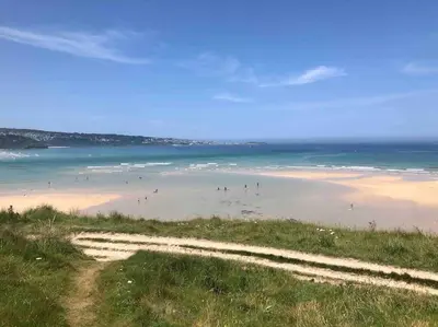 a group of people on a beach near the ocean at Family friendly home by the beach in Hayle