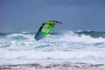 a person flying a kite in the ocean at Family friendly home by the beach in Hayle