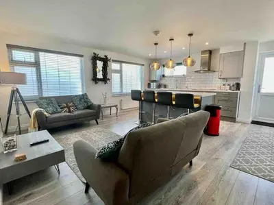 a living room with a couch and a kitchen at The Emslie Road Beach Flat in Falmouth