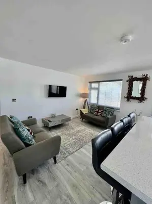 a living room with a couch and a table at The Emslie Road Beach Flat in Falmouth