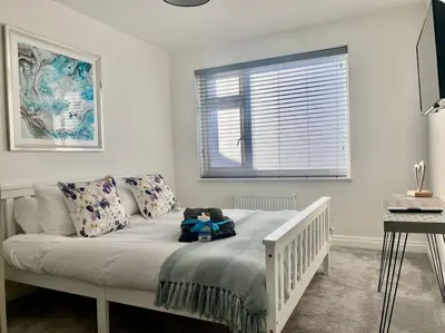 a bedroom with a bed with a teddy bear on it at The Emslie Road Beach Flat in Falmouth