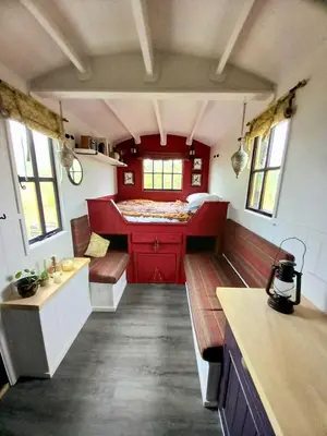 a small room with a bed and benches in a train at Field Hut in Wadebridge