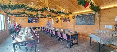 a dining room with tables and chairs and a chalkboard at Glamping Dome Elysian Fields in Helston