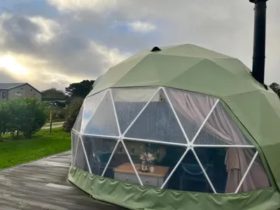 a large green tent on a wooden deck at Glamping Dome Elysian Fields in Helston