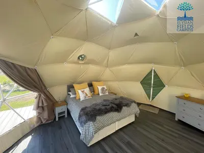 a bedroom in a tent with a bed in it at Glamping Dome Elysian Fields in Helston