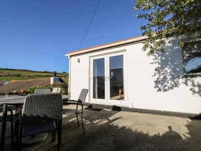 a small white house with a table and chairs at Salakee in Penzance