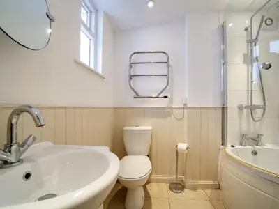 a bathroom with a toilet and a sink and a bath tub at Bosuns Locker in Port Isaac