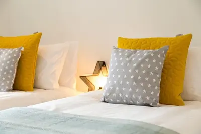 a white bed with two pillows on top of it at Luxury 3 floor Town House by Tolcarne Beach in Newquay