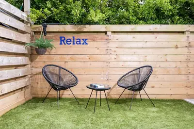 two chairs and a table in front of a fence at Luxury 3 floor Town House by Tolcarne Beach in Newquay