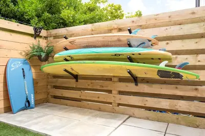 a group of surfboards on a wooden wall at Luxury 3 floor Town House by Tolcarne Beach in Newquay