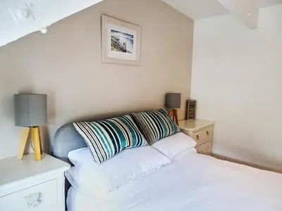 a bedroom with a bed and a pillow on the wall at The Mermaid Loft - Trebarwith Strand Cornwall in Tintagel