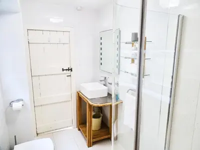 a bathroom with a sink and a shower at The Mermaid Loft - Trebarwith Strand Cornwall in Tintagel