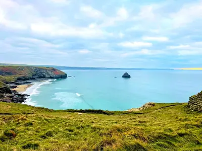 a view of the ocean with a rock in the water at The Mermaid Loft - Trebarwith Strand Cornwall in Tintagel