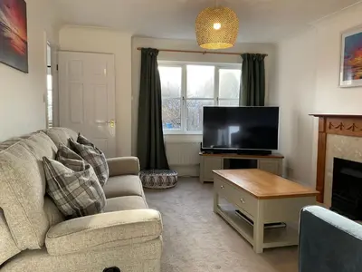 a living room with a couch and a flat screen tv at Newly Renovated 2 Bed house nr Fistral Beach & Gannel Estuary in Newquay