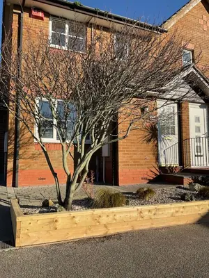 a tree in a wooden planter in front of a building at Newly Renovated 2 Bed house nr Fistral Beach & Gannel Estuary in Newquay