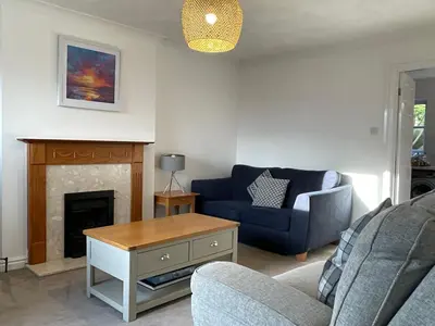 a living room with a blue couch and a fireplace at Newly Renovated 2 Bed house nr Fistral Beach & Gannel Estuary in Newquay