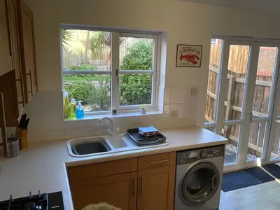 a kitchen with a sink and a washing machine at Newly Renovated 2 Bed house nr Fistral Beach & Gannel Estuary in Newquay