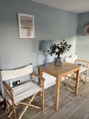 a dining room with a table and a table and chairs at Sandpiper in Fowey