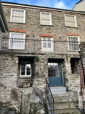 an old stone building with a blue door and stairs at Oystercatcher in Fowey