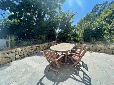 a wooden table with four chairs and a fountain at Cosy Rustic Annex in quiet Cornwall Village in Saint Wenn