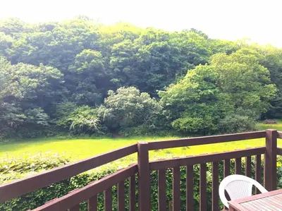 a balcony with a view of a park with trees at Rusey Cottage at Crackington Haven, near Bude and Boscastle, Cornwall in Bude