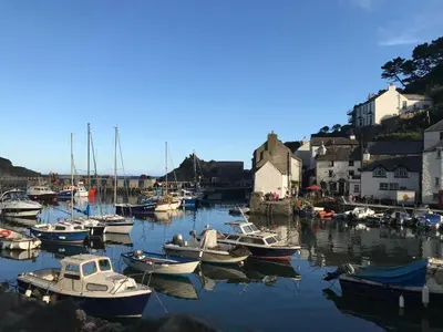 a bunch of boats are docked in a harbor at Corn Barn at East Trenean Farm -Luxury Cornish Barn Conversion sleeping 8 with hot tub, private garden, rural views and EV facilities in Looe