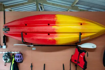 a yellow and red kayak on top of a table at Corn Barn at East Trenean Farm -Luxury Cornish Barn Conversion sleeping 8 with hot tub, private garden, rural views and EV facilities in Looe