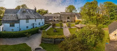 an aerial view of a house with a yard at Threshing Barn at East Trenean Farm -Stunning Cornish Cottage sleeping 6 with hot tub, private garden, rural views and EV facilities in East Looe