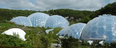 a group of domes in a park with trees at Threshing Barn at East Trenean Farm -Stunning Cornish Cottage sleeping 6 with hot tub, private garden, rural views and EV facilities in East Looe