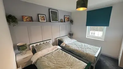 two twin beds in a room with a window at The Lounge in Newquay