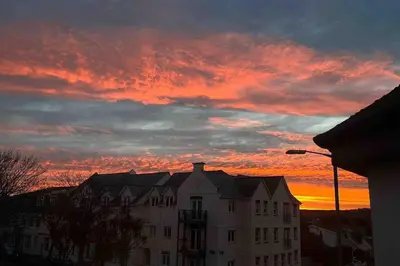 a building with a sunset in the background at The Lounge in Newquay