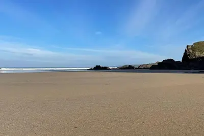 a sandy beach with rocks in the ocean at The Lounge in Newquay