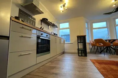 a kitchen with stainless steel appliances and a dining room at The Lounge in Newquay