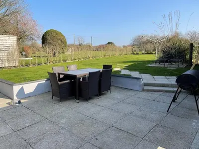 a patio with a table and chairs and a field at The Cottage, Cox Hill House, Cox Hill, Chacewater, TR4 8LY in Truro
