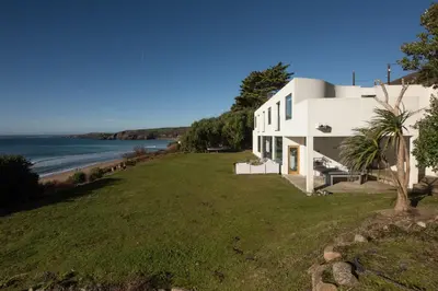 a white house with a view of the ocean at Footsteps from the beach - Hot tub - Cosy fireplace in Praa Sands