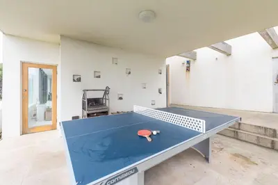 a ping pong table in the middle of a room at Footsteps from the beach - Hot tub - Cosy fireplace in Praa Sands