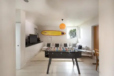 a living room with a table and a surfboard on it at Footsteps from the beach - Hot tub - Cosy fireplace in Praa Sands