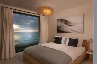 a bedroom with a bed and a large window at Footsteps from the beach - Hot tub - Cosy fireplace in Praa Sands