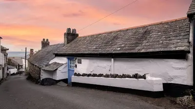 a group of birds sitting on a window sill of a building at Seascape Hideaways at Port Isaac in Port Isaac